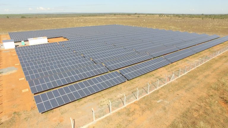 Várias placas de energia solar montadas em uma fazenda, definindo o início de um projeto pioneiro chamado de "fazenda solar".